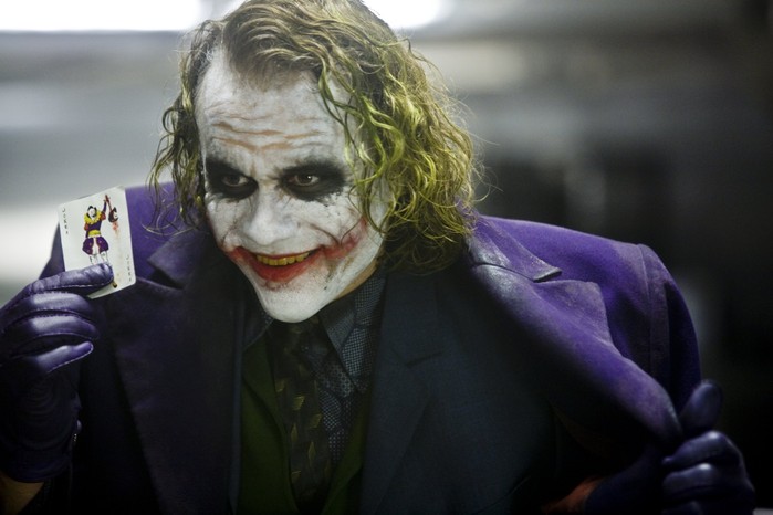 Heath Ledger as The Joker in The Dark Knight, holding up a playing card