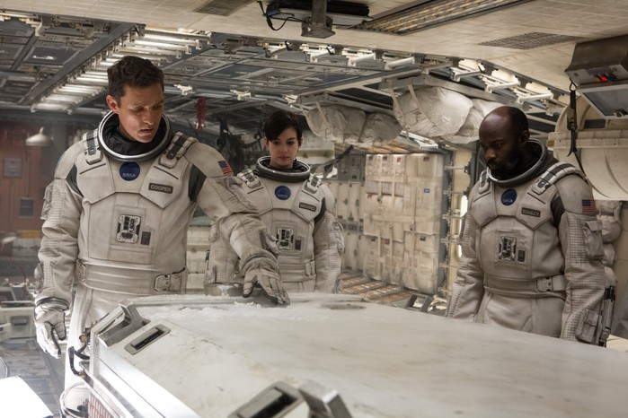 Matthew McConaughey as Cooper, Anne Hathaway as Amelia Brand and David Gyasi as Romilly in Interstellar, standing in a space ship