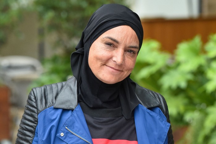 Sinéad O'Connor wearing a black headscarf and black-blue jacket