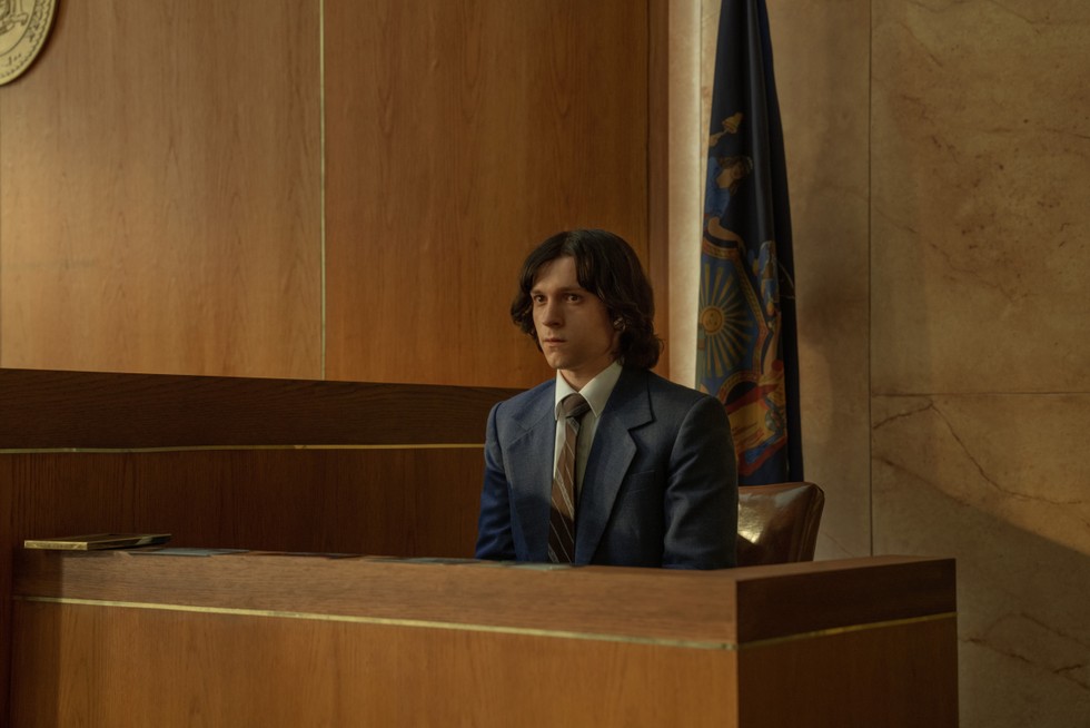 Tom Holland with long hair, sitting in a courtroom