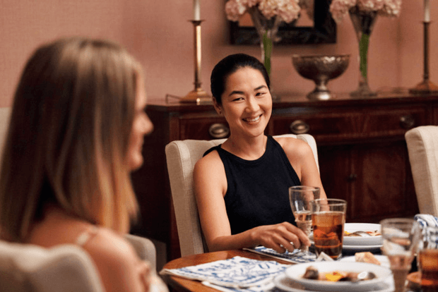 laurel smiling at susannah while sat at the dinner table